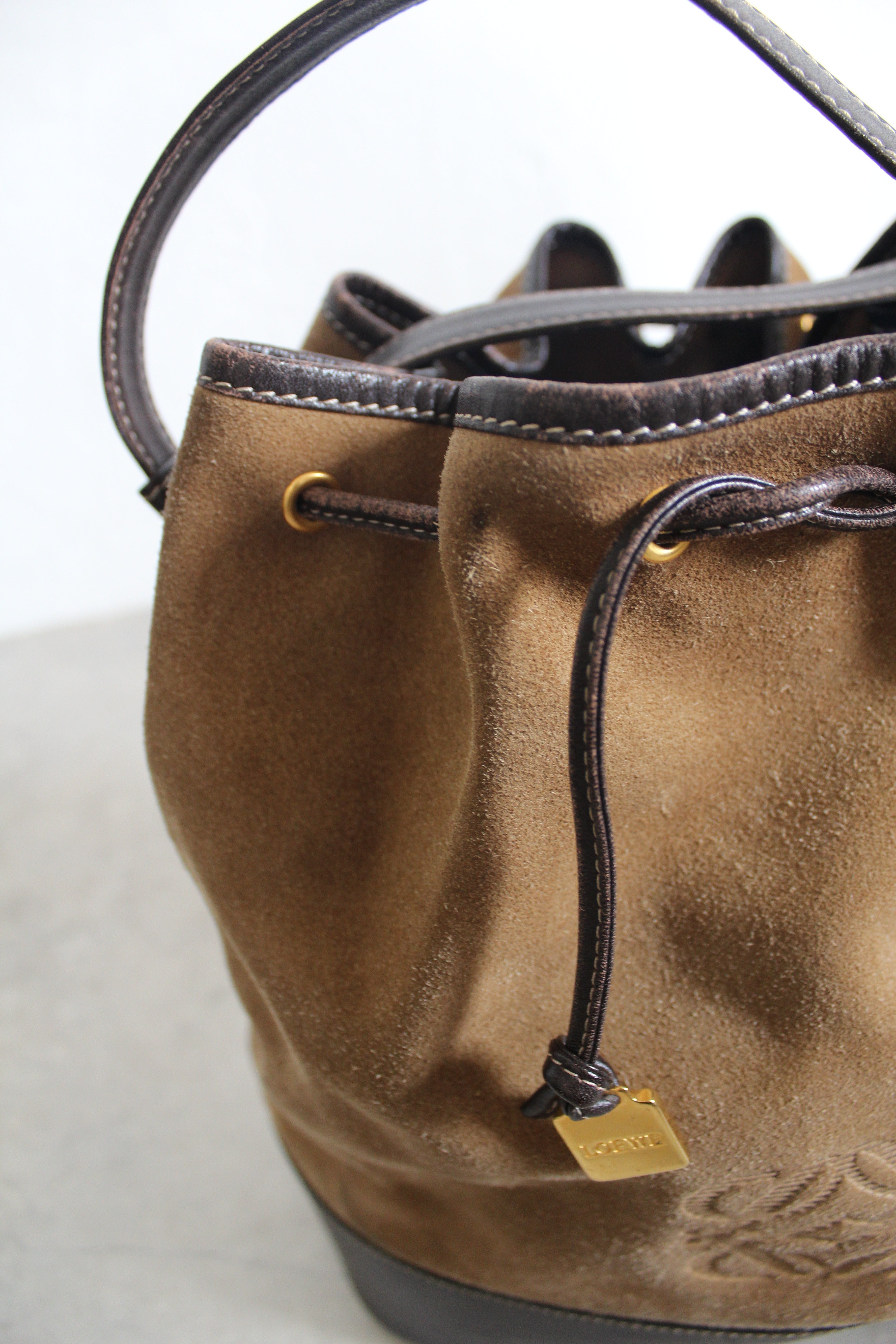 Anagram Suede Drawstring Bucket Bag