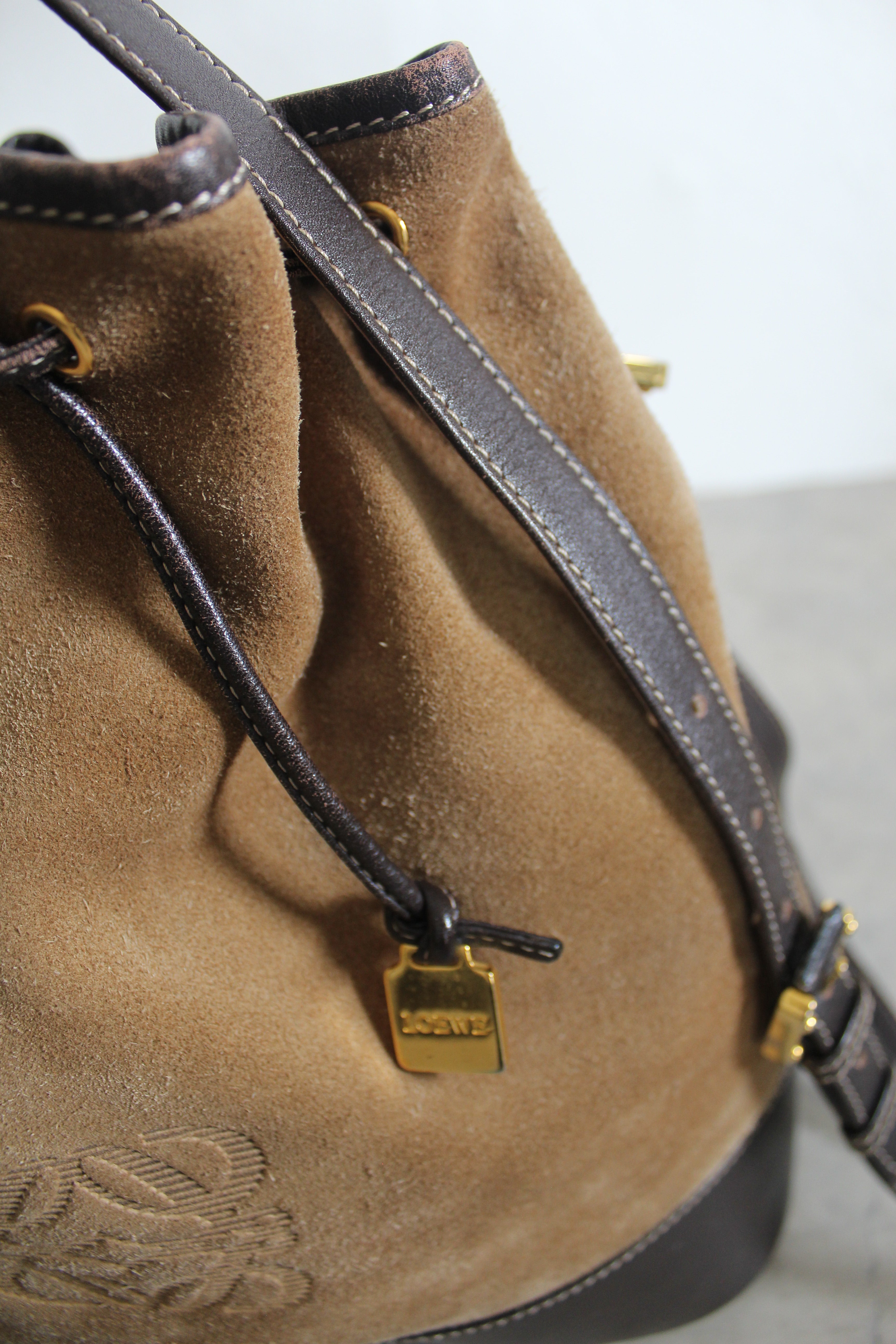 Anagram Suede Drawstring Bucket Bag